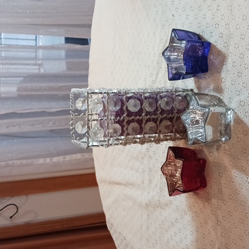 A purple candle with holder. Red, silver, and blue stars that can hold things.